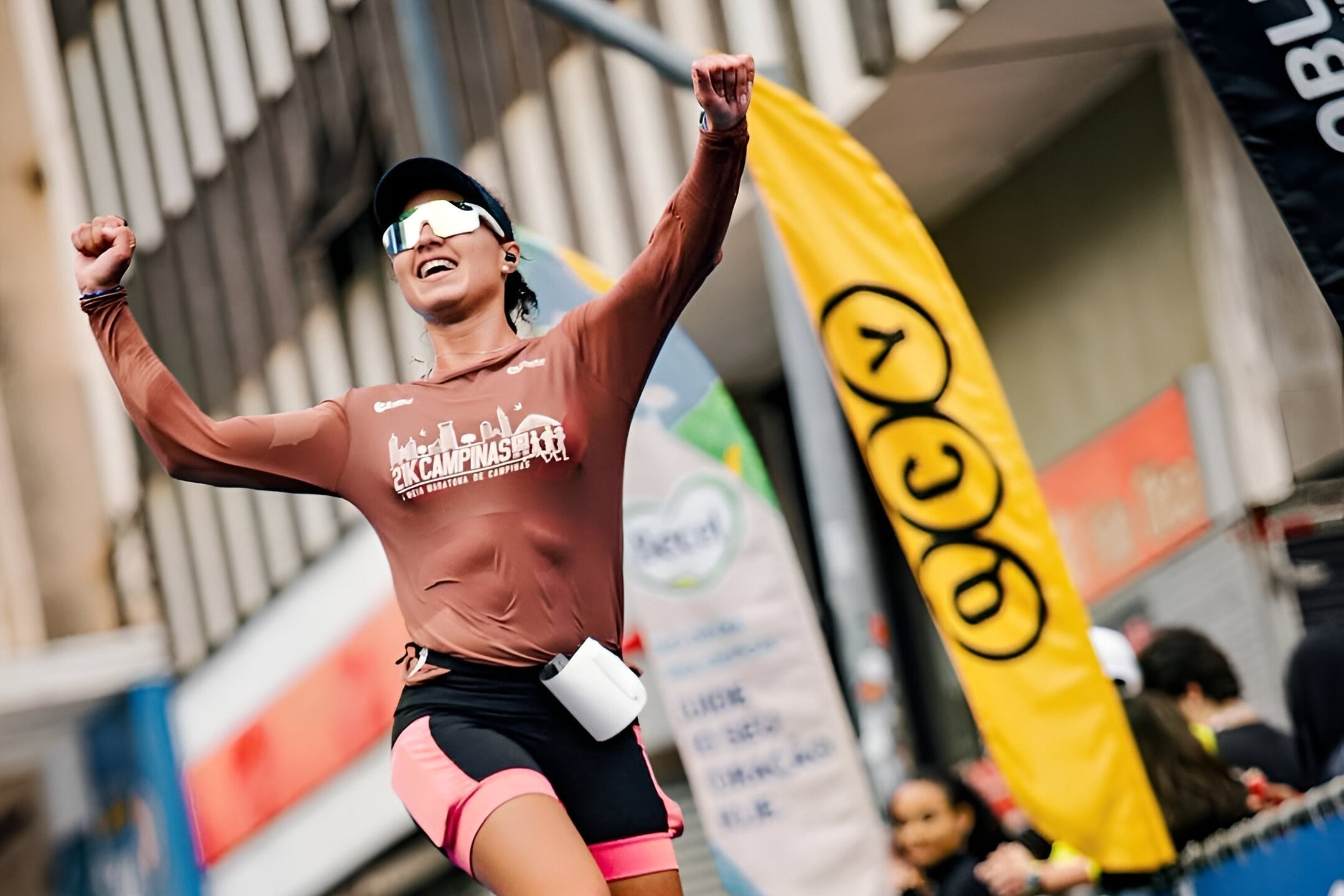 Läuferin jubelt nach dem Zieleinlauf beim 13. Campinas Halbmarathon, unterstützt von QCY.