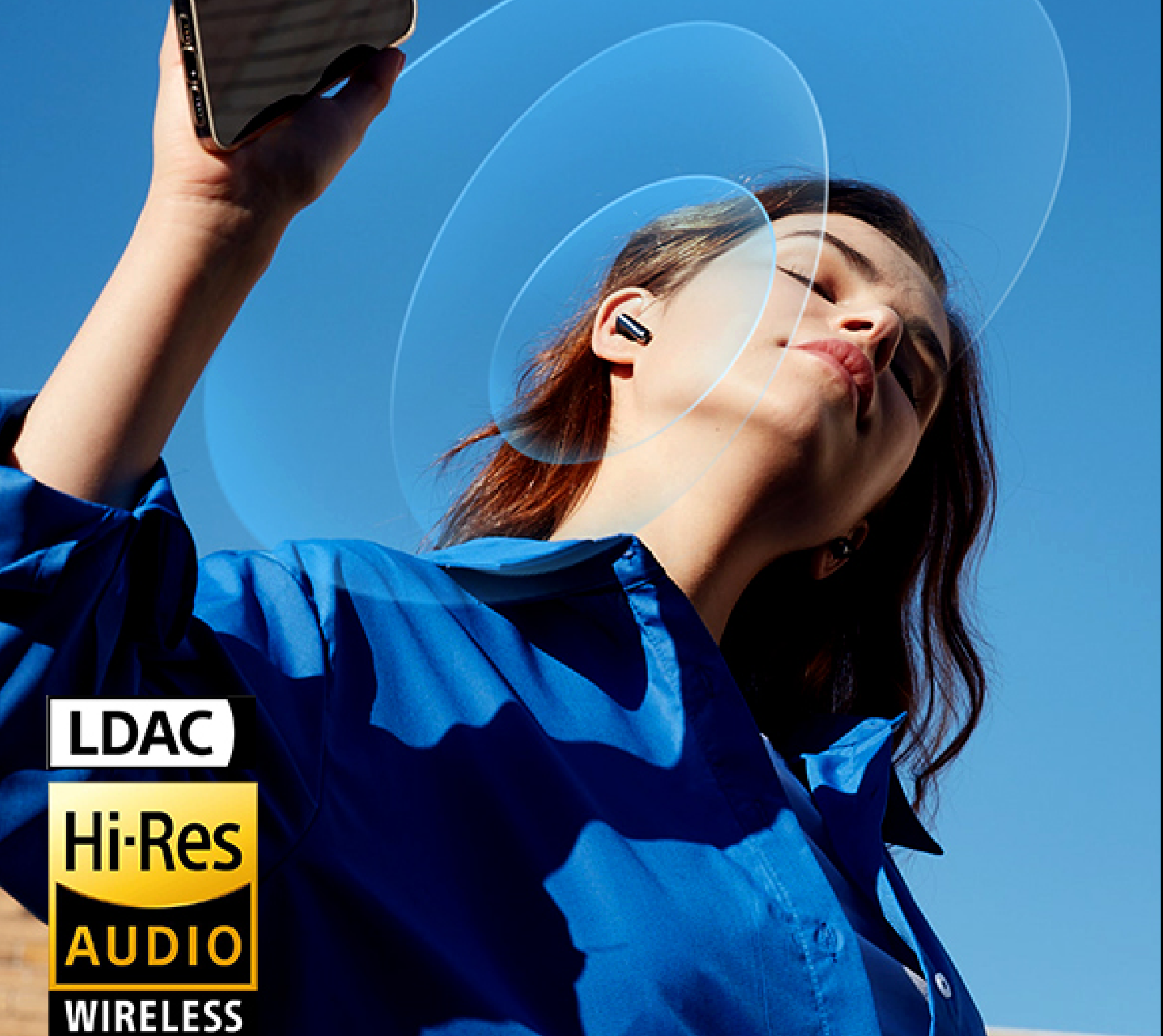 Donna con auricolari Hi-Res Audio wireless sotto un cielo azzurro, che gode della musica tramite tecnologia wireless LDAC.