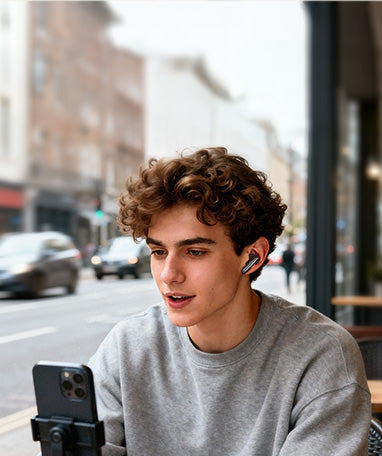 Giovane uomo con auricolari wireless e smartphone in città