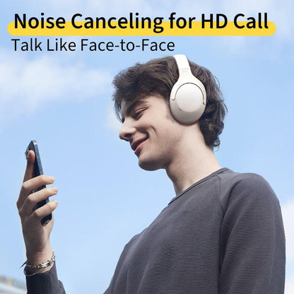 White QCY H3 Lite headphones with noise canceling for HD calls, shown on model using phone outdoors.