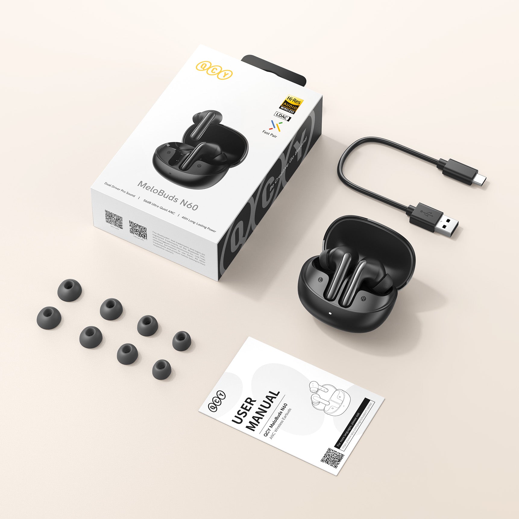 QCY MeloBuds N60 Auricolari wireless con custodia di ricarica, cavo USB, auricolari di ricambio e manuale d'uso su sfondo chiaro
